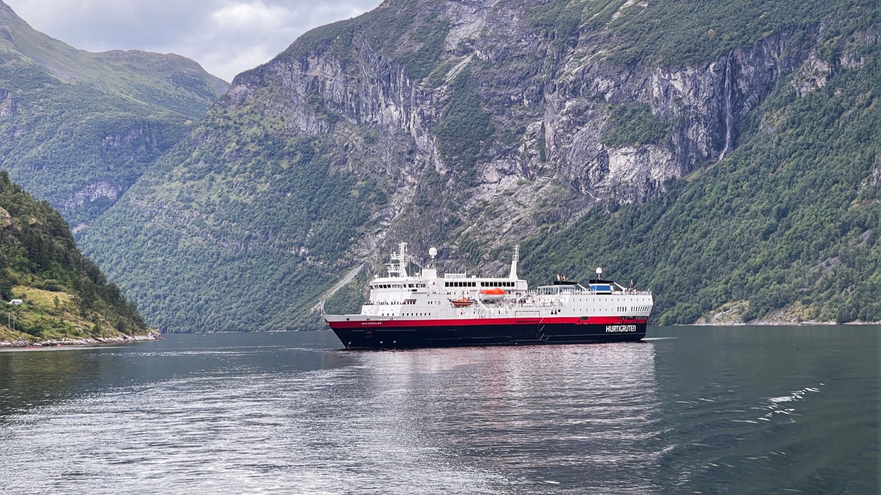 Cruise ship sailing through a Norwegian fjord